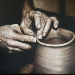 hands shaping a clay pot